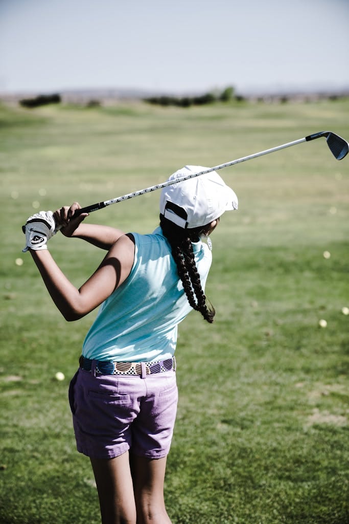 9 Complete Guide to a Perfect Golf Swing: Techniques, Tips, and Drills for Every Golfer 2 Girl practicing golf swing on a sunny day at the golf course